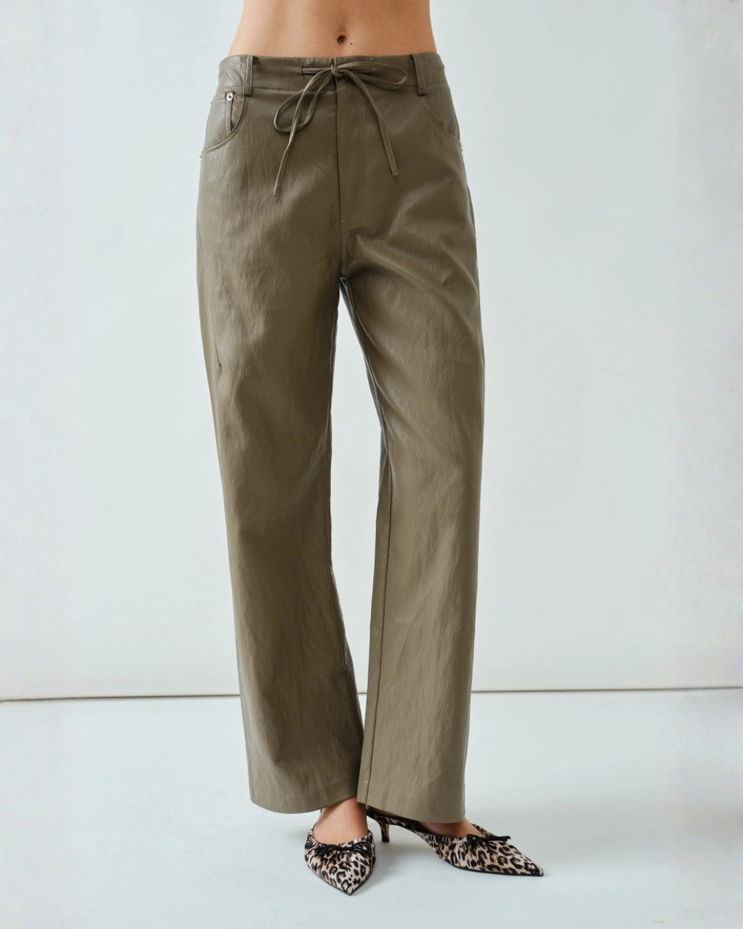 Soft brown faux leather pants styled in an elegant straight-leg design with a smooth, flexible finish.